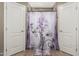 Charming shower stall featuring decorative shower curtain and neutral tile work, flanked by two doors at 3124 W Taro Ln, Phoenix, AZ 85027