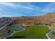An aerial shot shows a playground, basketball court, and green spaces enhancing community living amidst natural terrain at 32237 N 133Rd Dr, Peoria, AZ 85383