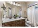 Bathroom featuring double sinks, a large mirror, and ample counter space at 32237 N 133Rd Dr, Peoria, AZ 85383