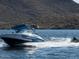 A Regal wakeboard boat on the water, pulling a tuber against a mountainous backdrop at 32237 N 133Rd Dr, Peoria, AZ 85383