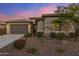 Charming single-Gathering home featuring a two-car garage, complemented by desert landscaping and colorful bushes at 32237 N 133Rd Dr, Peoria, AZ 85383
