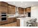 A gourmet kitchen featuring stainless steel appliances, dark cabinets, white counters, and a large center island at 32237 N 133Rd Dr, Peoria, AZ 85383