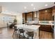 Modern kitchen with stainless steel appliances, white countertops, dark wood cabinets and a large island with barstool seating at 32237 N 133Rd Dr, Peoria, AZ 85383