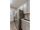 Modern laundry room with gray cabinets, sink, and stainless steel refrigerator at 32237 N 133Rd Dr, Peoria, AZ 85383