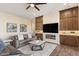 Comfortable living room with built-in cabinets, a fireplace, and a contemporary design at 32237 N 133Rd Dr, Peoria, AZ 85383