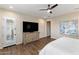 This bedroom features a dresser, ceiling fan, and stylish door with plantation shutters at 32237 N 133Rd Dr, Peoria, AZ 85383