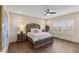 Serene main bedroom featuring plantation shutters, a ceiling fan, and a stylish wood-trimmed bedframe at 32237 N 133Rd Dr, Peoria, AZ 85383