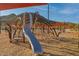 Community playground featuring a slide and climbing structure, creating a fun and engaging play area for children at 32237 N 133Rd Dr, Peoria, AZ 85383