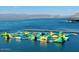 Water park with an inflatable obstacle course on a lake, perfect for summer fun and recreation at 32237 N 133Rd Dr, Peoria, AZ 85383