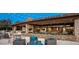 Inviting outdoor patio with comfortable seating, a fireplace, and string lights for a cozy ambiance at 32237 N 133Rd Dr, Peoria, AZ 85383