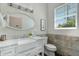 Charming bathroom features a marble vanity with a farmhouse sink, decorative mirror, and tiled accent wall at 3229 E Campbell Ave, Phoenix, AZ 85018