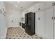 Well-equipped laundry room with ample storage cabinets, a sleek black refrigerator, and stylish tile flooring at 3229 E Campbell Ave, Phoenix, AZ 85018
