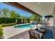 Inviting backyard features a sparkling pool, lush greenery, and comfortable outdoor seating under a covered patio at 3229 E Campbell Ave, Phoenix, AZ 85018
