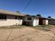 Home's exterior with peeling paint and a dirt backyard under a clear blue sky at 3419 W Glenn Dr, Phoenix, AZ 85051