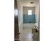 Bathroom features tiled bathtub and vanity with opened cabinets at 3419 W Glenn Dr, Phoenix, AZ 85051