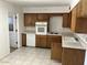 Kitchen features tile flooring, white appliances and wood cabinets at 3419 W Glenn Dr, Phoenix, AZ 85051