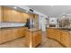 Open kitchen with a tile floors, wood cabinets, and fireplace in adjacent room at 3623 S Agave Way, Chandler, AZ 85248