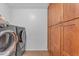 Laundry room featuring modern washer/dryer and wooden cabinet space at 3623 S Agave Way, Chandler, AZ 85248