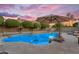 Backyard swimming pool featuring rock details and desert landscaping, complete with patio umbrella for shade at 3623 S Agave Way, Chandler, AZ 85248