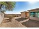 Home's backyard with desert landscaping, including covered patio and lush green tree at 3885 E Lambeth Pl, San Tan Valley, AZ 85140