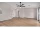 Large living area showcasing light wood floors, a modern ceiling fan, and arched doorways at 3885 E Lambeth Pl, San Tan Valley, AZ 85140