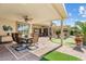 Relax in this backyard covered patio with dining area, putting green, and lush landscaping at 3933 E Meadowview Dr, Gilbert, AZ 85298