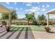 Landscaped backyard features a putting green, patio, and wrought iron fence with golf course views at 3933 E Meadowview Dr, Gilbert, AZ 85298