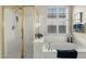 Bright bathroom featuring a soaking tub, glass shower, and natural light from the shuttered window at 3933 E Meadowview Dr, Gilbert, AZ 85298