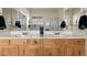 Bathroom with a double vanity, wood cabinets, tiled floors, and a shower with glass doors, and privacy window at 3933 E Meadowview Dr, Gilbert, AZ 85298
