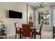 Dining area featuring a four-seat table set, a wall-mounted television, and large windows with outdoor views at 3933 E Meadowview Dr, Gilbert, AZ 85298