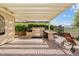 Outdoor kitchen under pergola includes built in barbeque, dining table, and beautiful landscaping for perfect outdoor enjoyment at 3933 E Meadowview Dr, Gilbert, AZ 85298