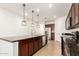 Well-lit kitchen featuring a large island with dark countertops and modern pendant lighting at 40800 W Rio Grande Dr, Maricopa, AZ 85138
