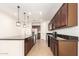 Open kitchen with stainless steel appliances and dark wood cabinetry at 40800 W Rio Grande Dr, Maricopa, AZ 85138