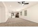 Bright and open living space with neutral carpet, ceiling fan, and a clear view into the modern kitchen at 40800 W Rio Grande Dr, Maricopa, AZ 85138