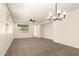Bright living room with neutral carpet, a ceiling fan, and views into the kitchen and backyard at 40800 W Rio Grande Dr, Maricopa, AZ 85138