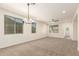 Spacious living room with neutral-colored carpet, modern ceiling fan and light fixture, and natural light at 40800 W Rio Grande Dr, Maricopa, AZ 85138