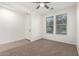 A well-lit living room with carpet and tile featuring large windows and a ceiling fan for brightness and comfort at 40800 W Rio Grande Dr, Maricopa, AZ 85138