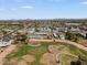 Expansive aerial view showcasing townhomes, a golf course, and a pool with mountain views in the distance at 418 E Woodman Dr, Tempe, AZ 85283
