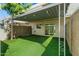 Cozy backyard with synthetic turf, covered patio with string lights, and privacy walls at 418 E Woodman Dr, Tempe, AZ 85283