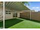 Charming backyard featuring low maintenance synthetic turf and a covered patio area at 418 E Woodman Dr, Tempe, AZ 85283