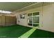 View of the backyard featuring synthetic turf, a covered patio, and a sliding glass door at 418 E Woodman Dr, Tempe, AZ 85283
