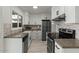 Stylish kitchen boasts white cabinets, stainless steel appliances, and complementary countertops at 418 E Woodman Dr, Tempe, AZ 85283