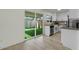 Kitchen boasts white cabinets, stainless appliances, backyard view, and modern wood-look flooring at 418 E Woodman Dr, Tempe, AZ 85283