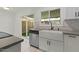 Kitchen features stainless steel appliances, white cabinetry, sliding door access, and sleek countertops at 418 E Woodman Dr, Tempe, AZ 85283