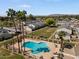 Aerial view of a sparkling blue community pool and a lounging area surrounded by well-manicured green spaces at 418 E Woodman Dr, Tempe, AZ 85283