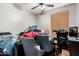 A cluttered bedroom with two chairs and a ceiling fan at 4337 E Vaughn Ave, Gilbert, AZ 85234
