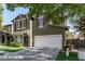 Charming two-story home featuring green exterior, red shutters, well-kept lawn and a two car garage at 4337 E Vaughn Ave, Gilbert, AZ 85234