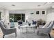 Bright living room with travertine tile flooring, large windows, elegant furniture, and crystal chandeliers at 4337 E Vaughn Ave, Gilbert, AZ 85234