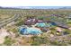 Aerial view of community swimming pool and recreation center, surrounded by green spaces and mature trees on a sunny day at 4617 W Cottontail Rd, Phoenix, AZ 85086