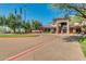 Elegant clubhouse entrance with well-manicured landscaping, flags, and ample parking for guests at 4617 W Cottontail Rd, Phoenix, AZ 85086